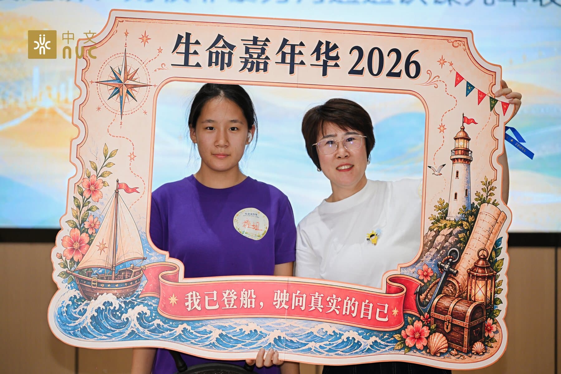 两位伙伴手持生命嘉年华 2026 主题相框合影